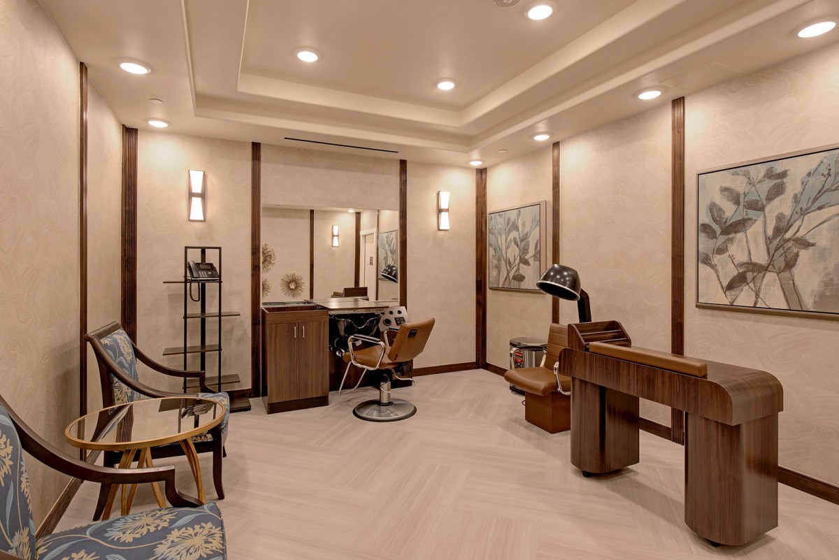A luxurious salon interior featuring modern furniture and elegant decor with warm lighting.