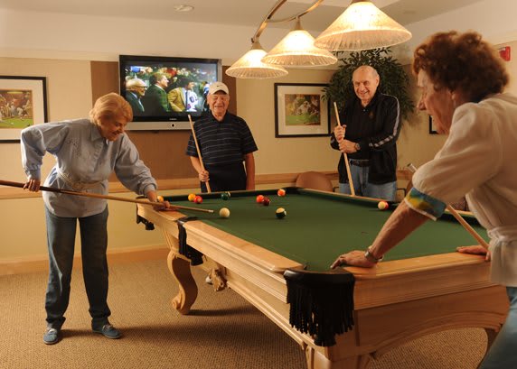 A group of people enjoying a game of billiards indoors.