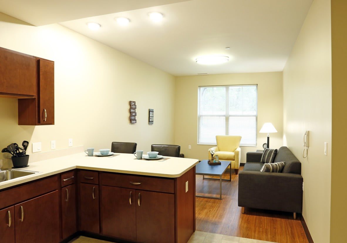 A modern and minimalist apartment interior featuring a kitchen and living room with stylish furniture.