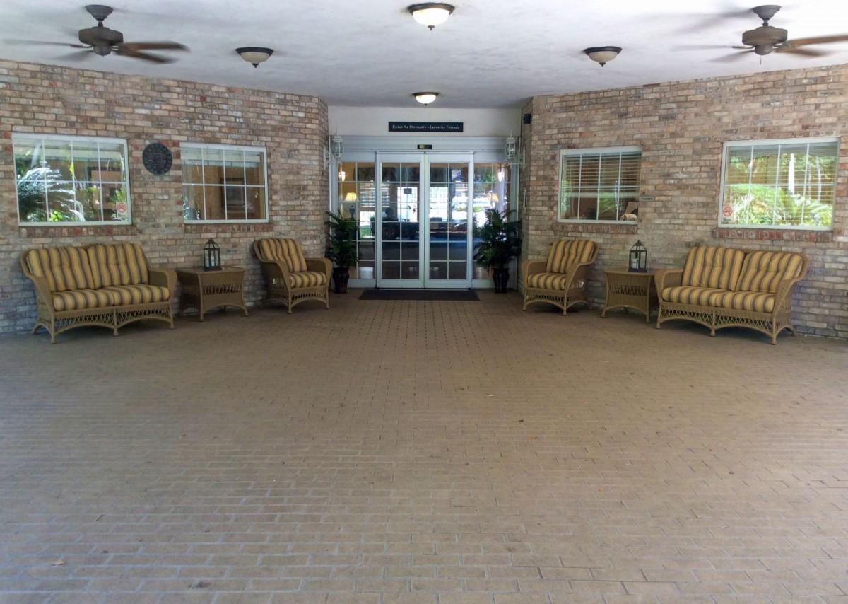 An entrance area with wicker chairs and brick walls.