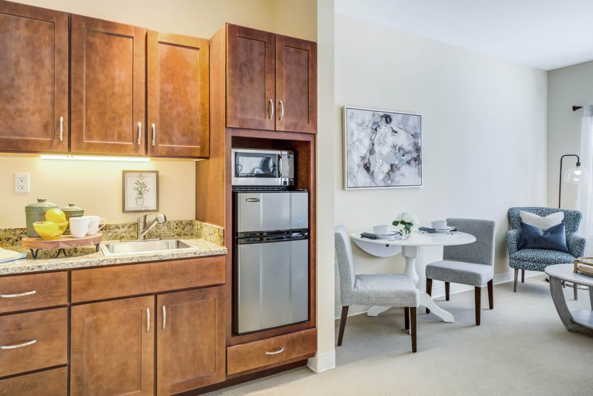 A cozy kitchenette with wooden cabinets and a small dining area.