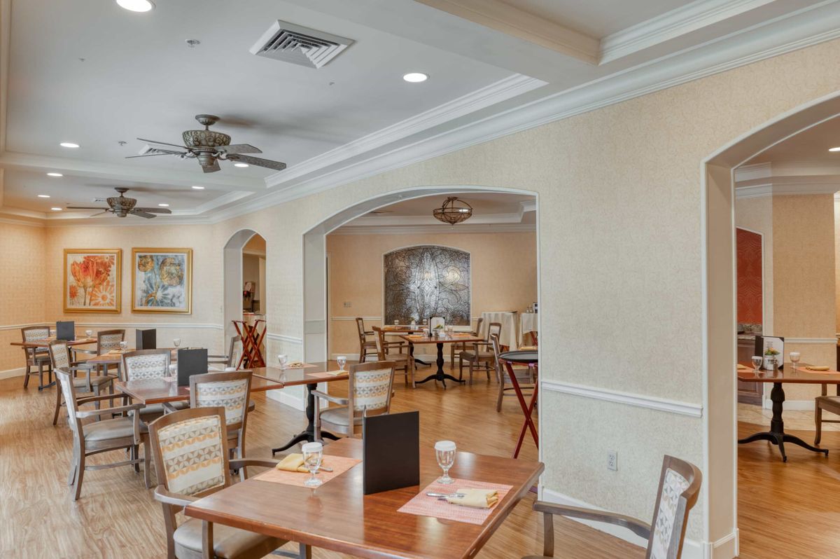 A spacious and elegantly decorated dining area with neatly arranged tables and chairs.
