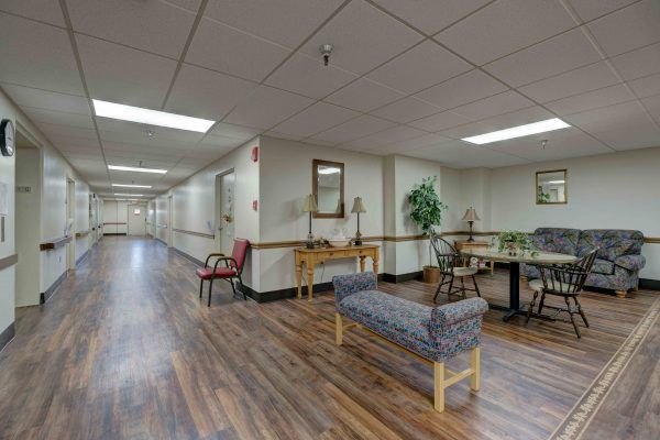 A hallway with a waiting area, featuring seating and decor.