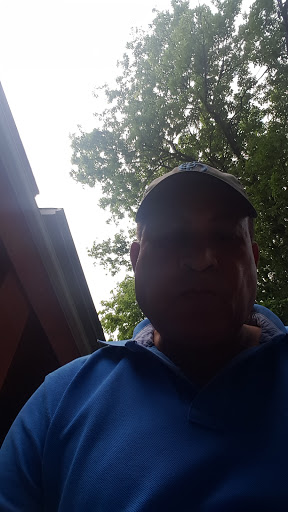 A person wearing a hat and a blue shirt appears to be outdoors.