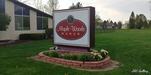 The welcoming entrance sign of Maple Woods Manor, surrounded by a well-maintained garden.