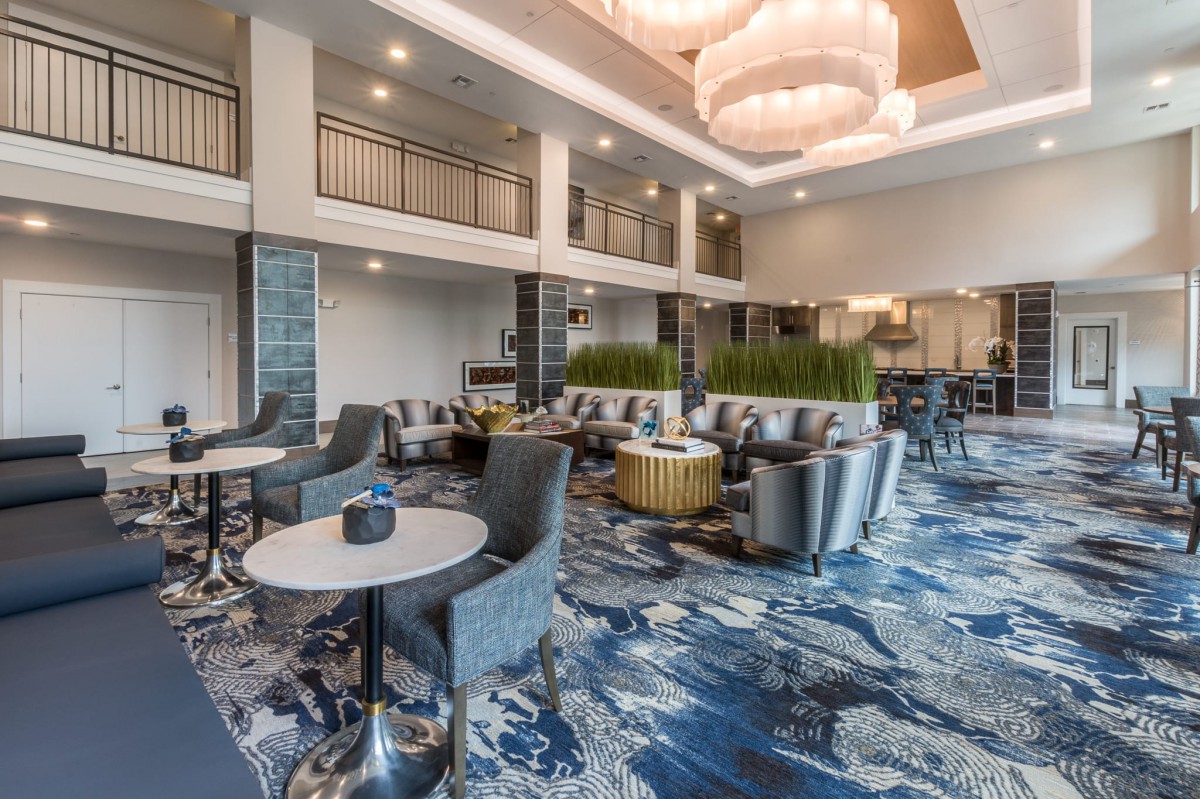 A modern lobby with stylish furniture and elegant chandeliers.