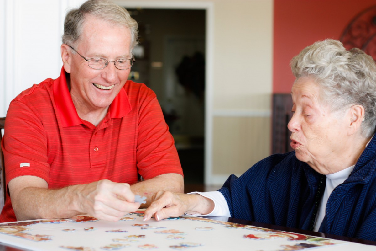 Two elderly individuals engaging in a pleasant conversation at a table.