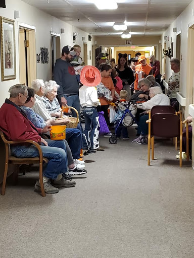 A vibrant gathering of individuals in a community center hallway, showcasing social interaction among the elderly.