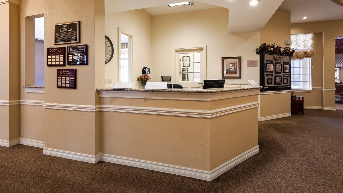 A spacious reception area with a central desk and warm decor.