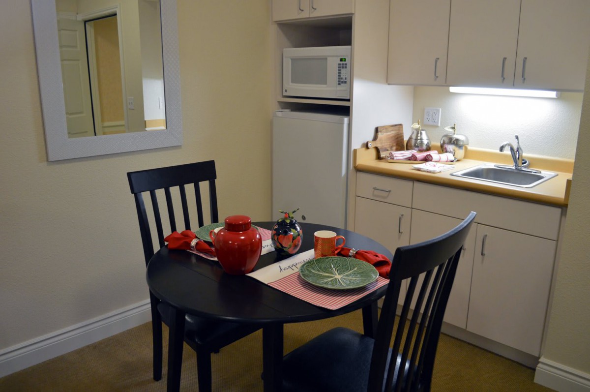 A cozy kitchen with a small dining table set for a meal.