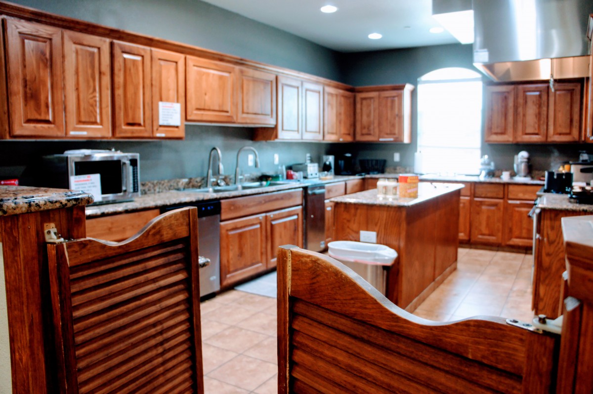 A spacious kitchen featuring wooden cabinets and stainless steel appliances.