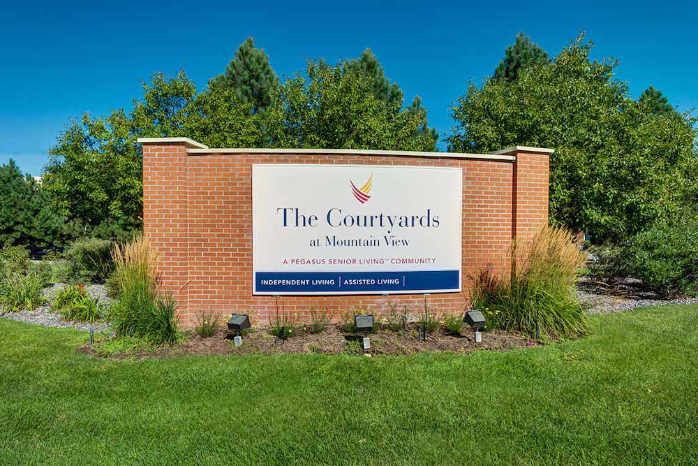 Entrance sign for The Courtyards at Hidden Valley, surrounded by landscaping.