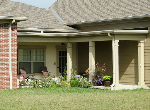 A charming residential house featuring a porch and a well-maintained garden.