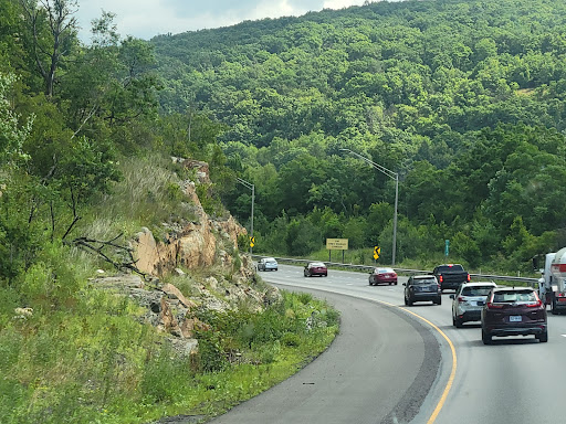 A scenic view of a curving road surrounded by lush green mountains.