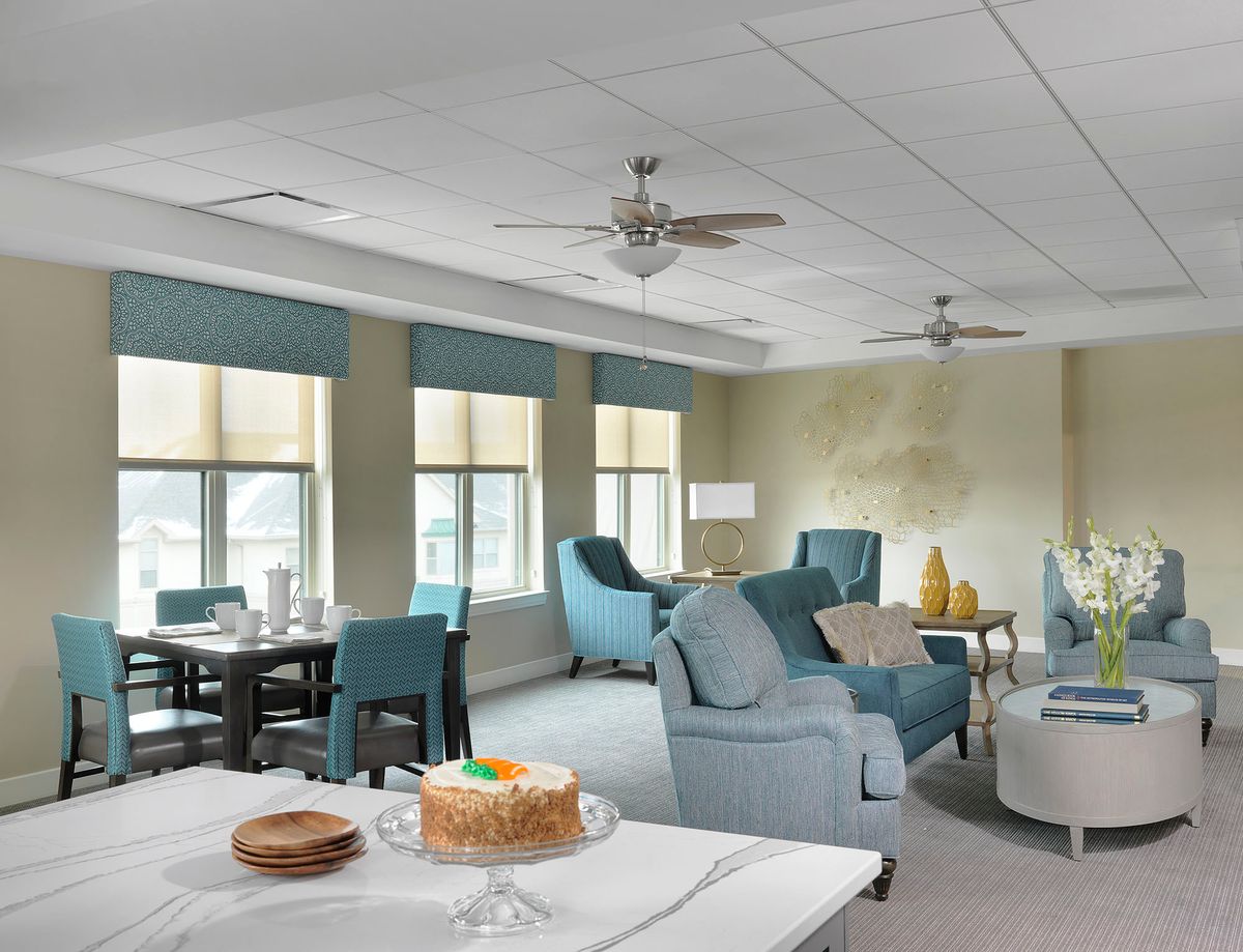 A well-furnished living room with sofas, a table, and a cake on display.