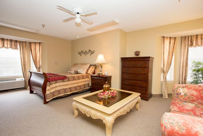 A cozy bedroom featuring a bed, dresser, coffee table, and elegant decor.