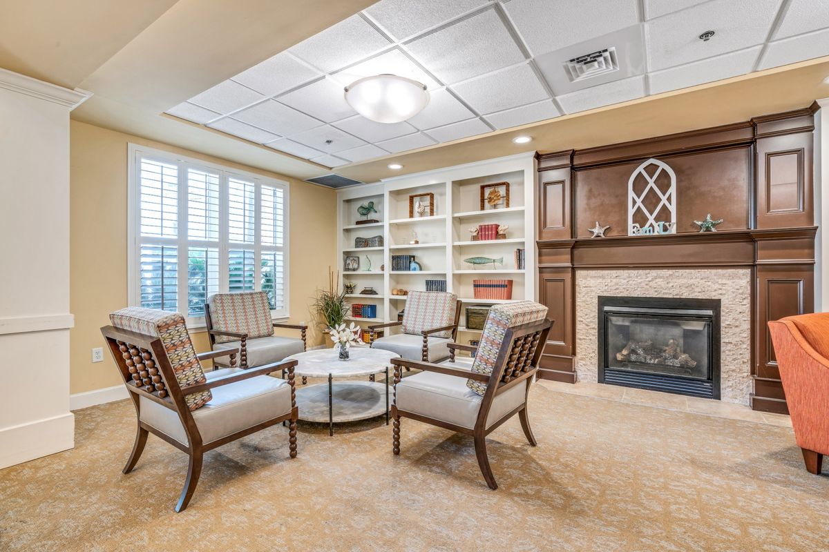 A cozy living room with comfortable seating, a coffee table, bookshelves, and a fireplace.