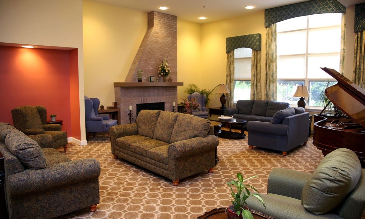 A cozy living room with multiple sofas and a fireplace.