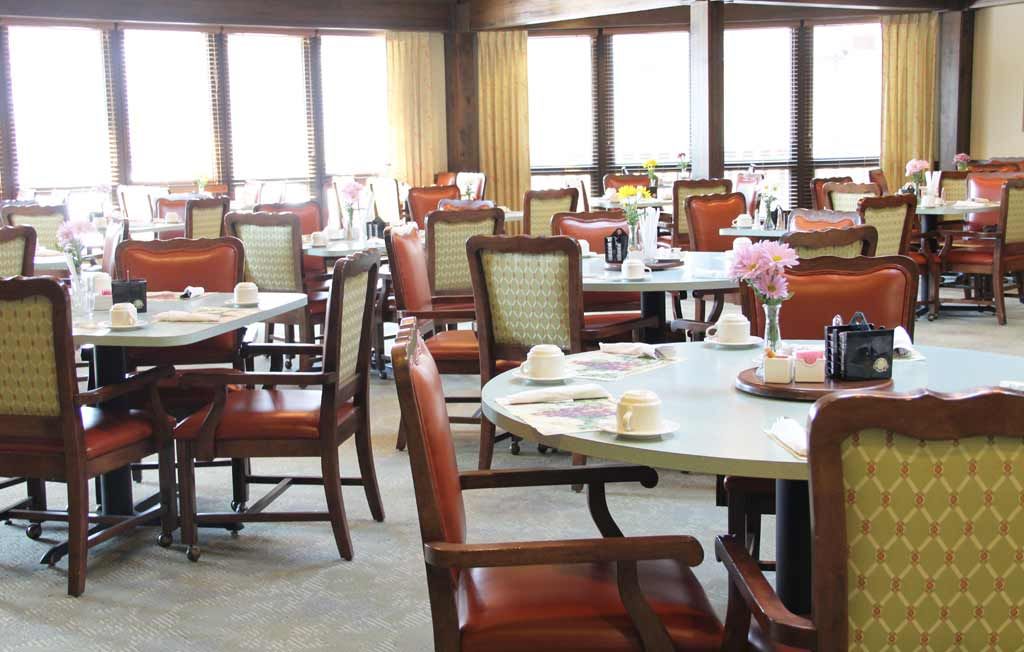 An empty dining room with neatly arranged tables and chairs.