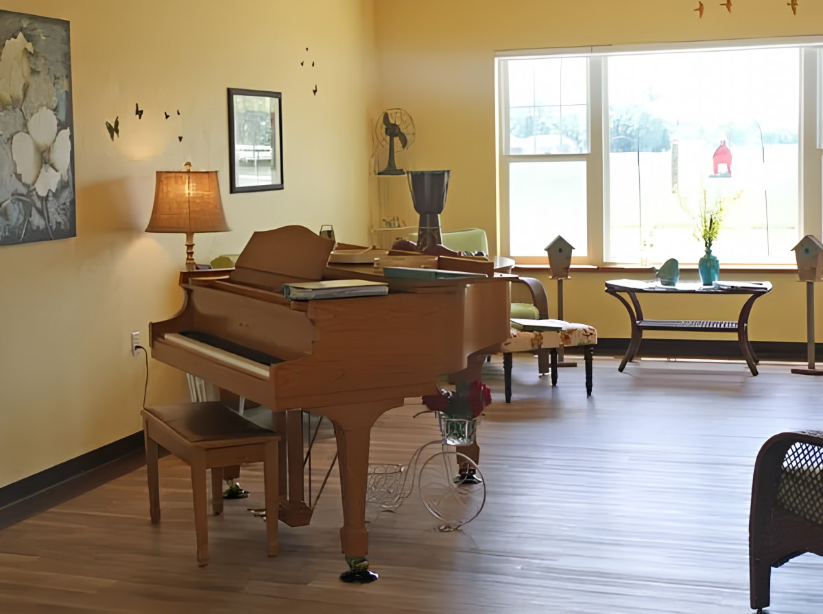 A cozy living room featuring a grand piano, warm lighting, and elegant decor.