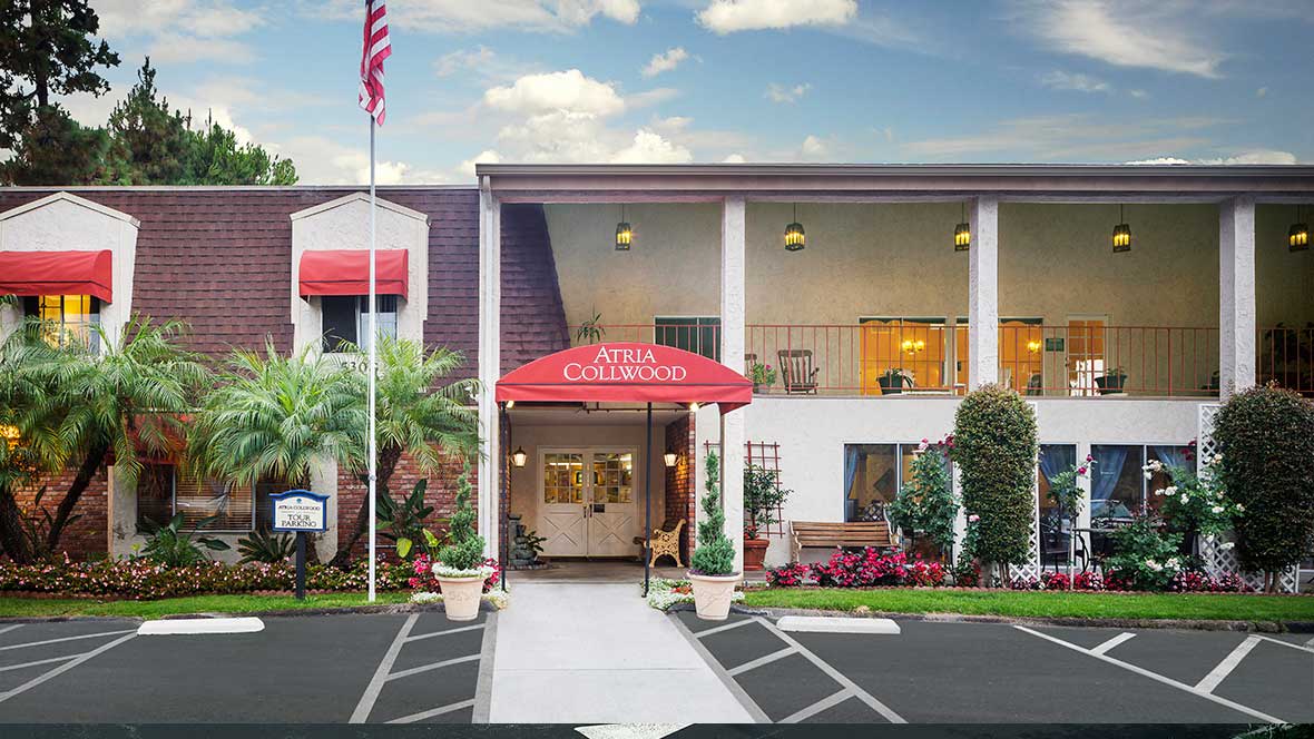 Exterior view of a hotel entrance with red awning and American flag.