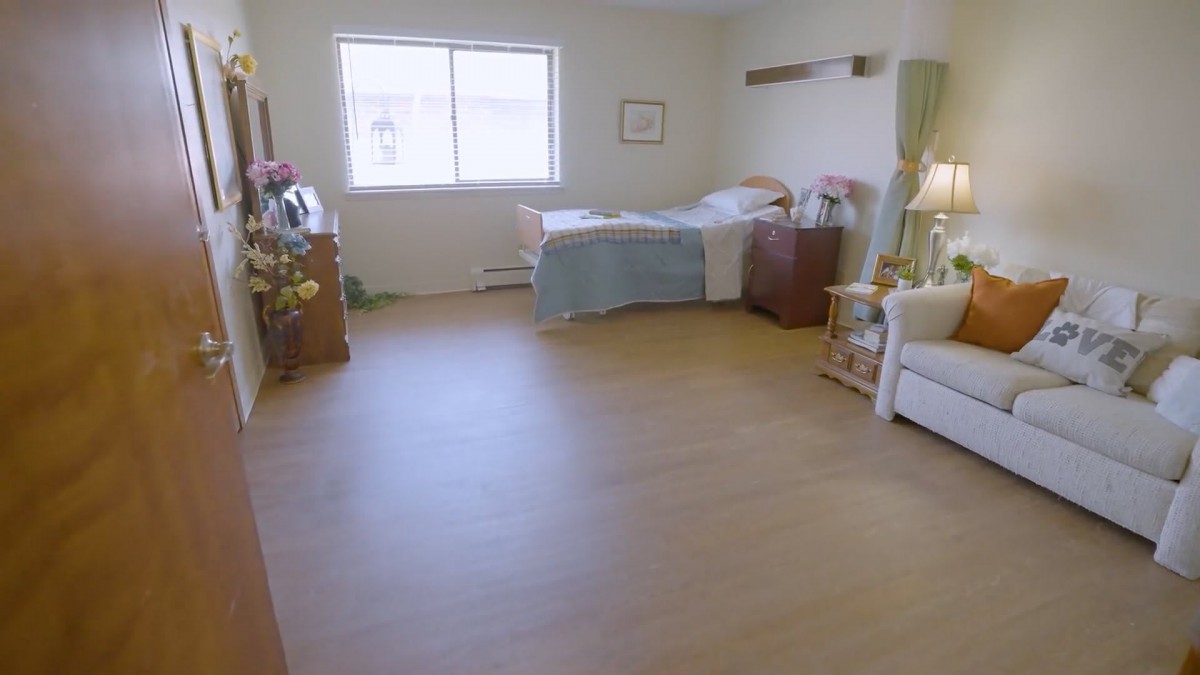 A clean and minimalist hospital room with a single bed and window.
