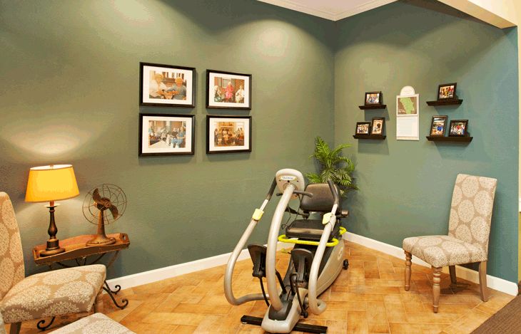 A well-decorated exercise room featuring fitness equipment and tasteful wall art.