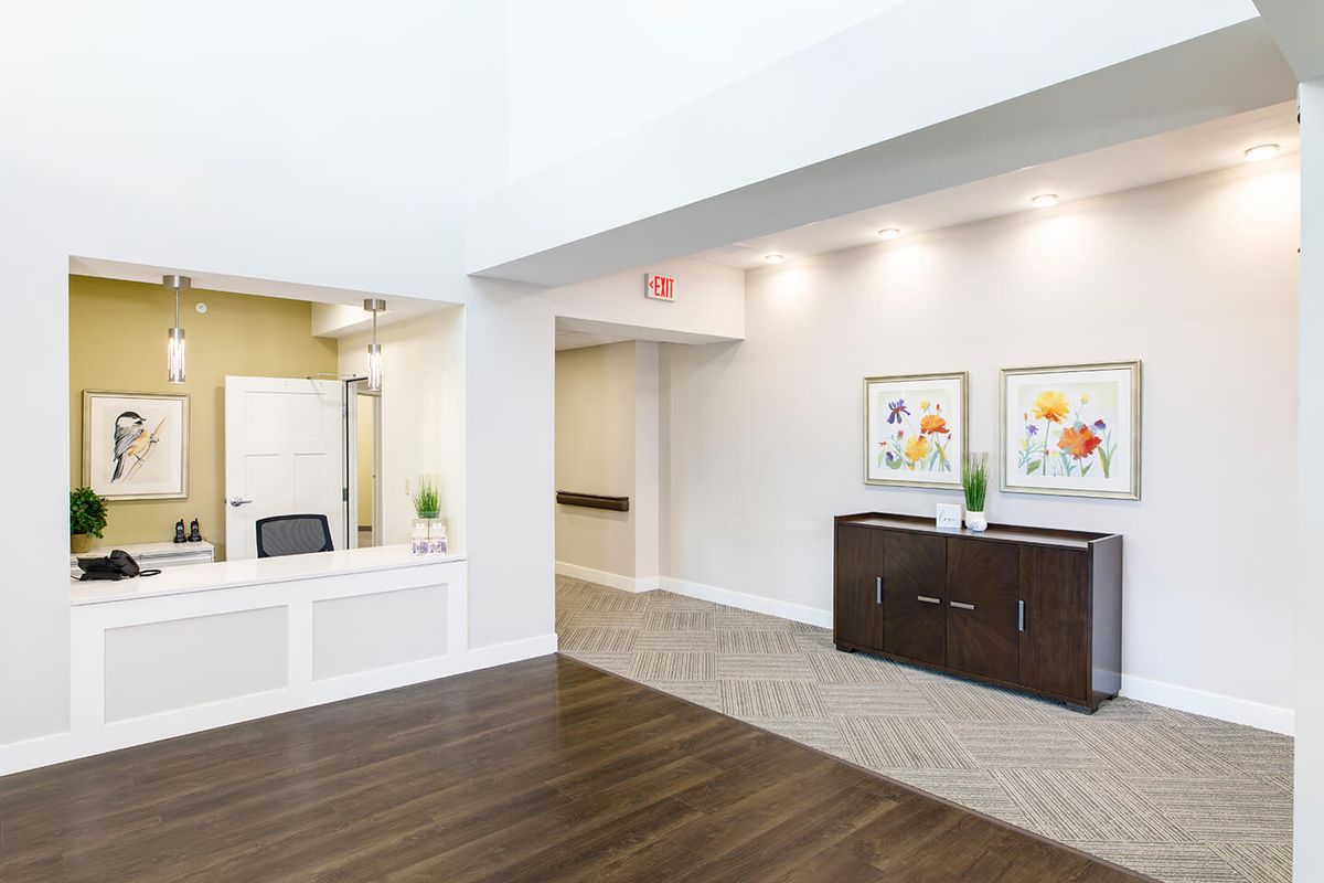 A modern office lobby featuring a reception desk and artwork on the walls.