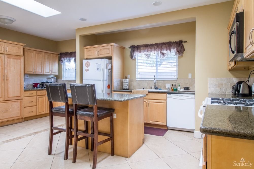 A spacious kitchen with an island and bar stools.