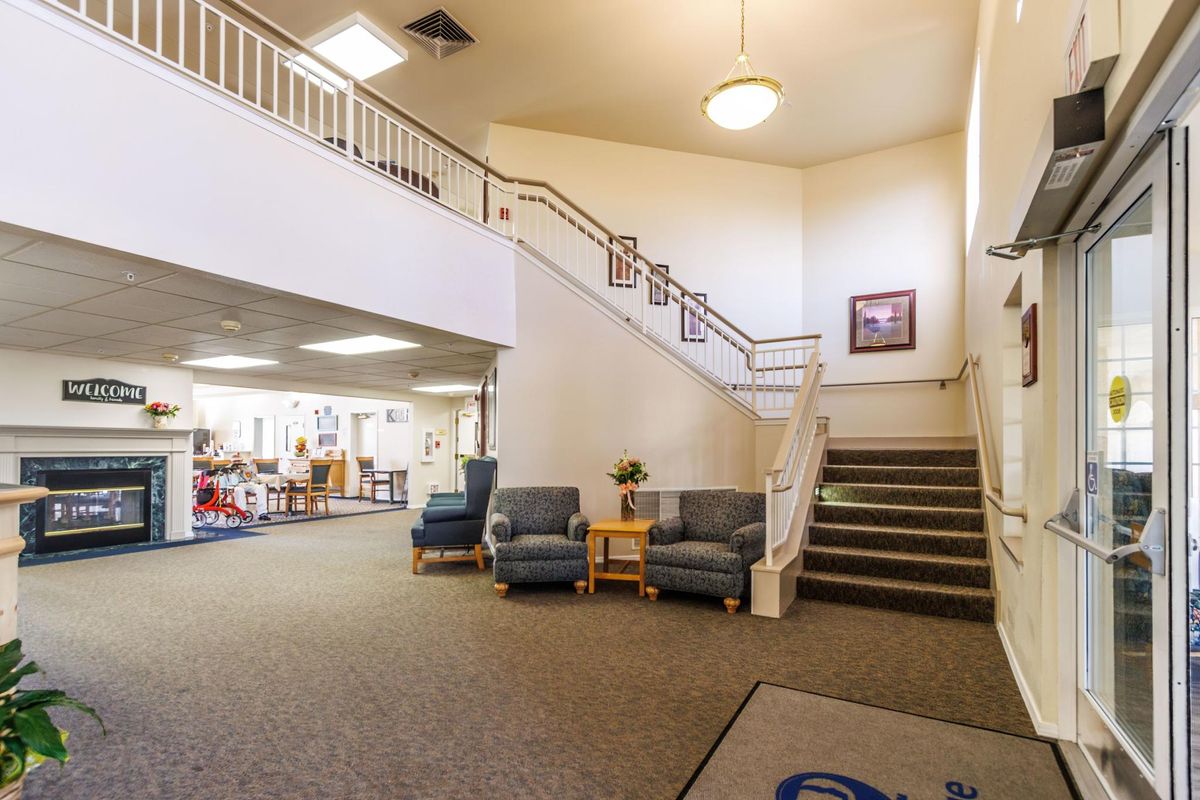 A spacious lobby with seating and a staircase leading to an upper level.