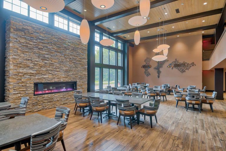 A modern dining area with a stylish fireplace, large windows, and elegant lighting.