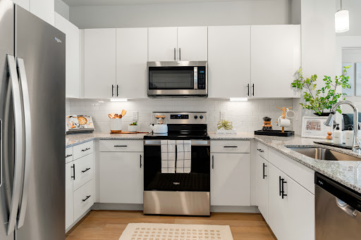 A modern kitchen featuring sleek white cabinets and stylish appliances.