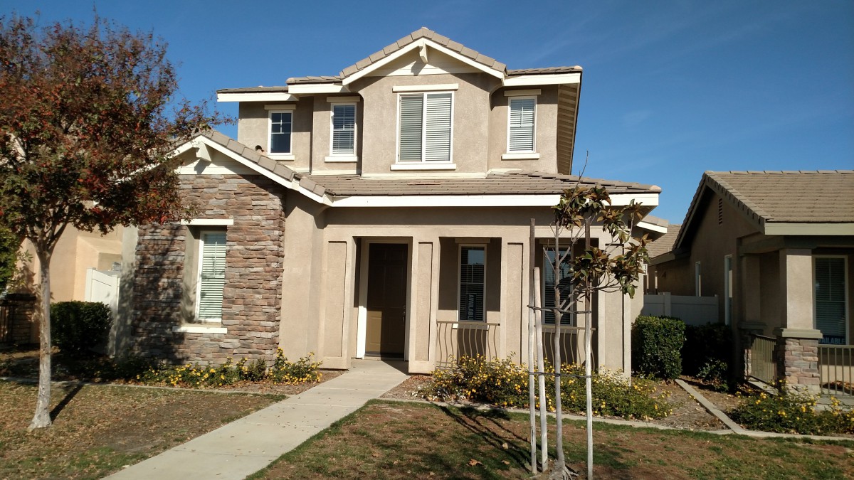 A two-story suburban house with a stone and stucco exterior.