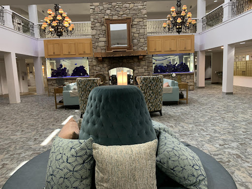 A cozy hotel lobby featuring elegant furniture, a stone fireplace, and stylish lighting.