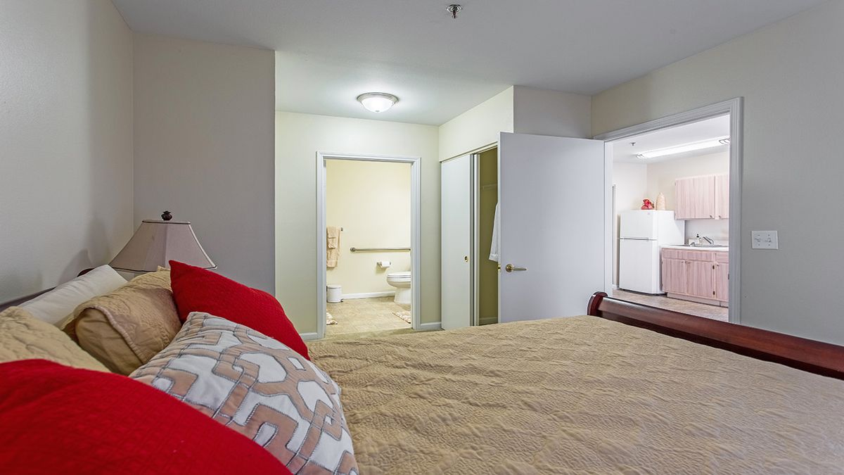 A cozy bedroom with view into an adjoining bathroom.