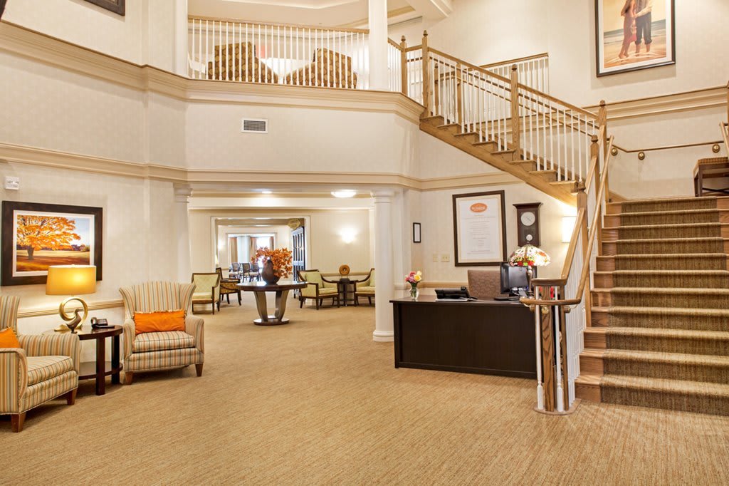 Spacious and elegantly designed lobby with comfortable seating and a wooden staircase.