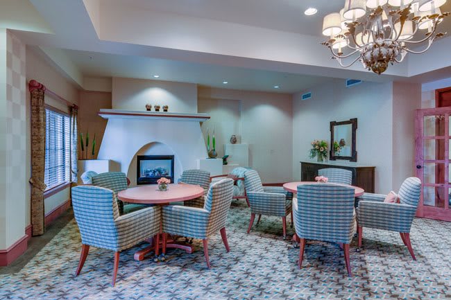 A cozy dining area with a fireplace and elegant chandelier.
