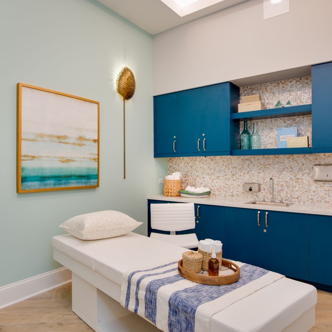 A serene spa room featuring a massage table, soft lighting, and calming decor.