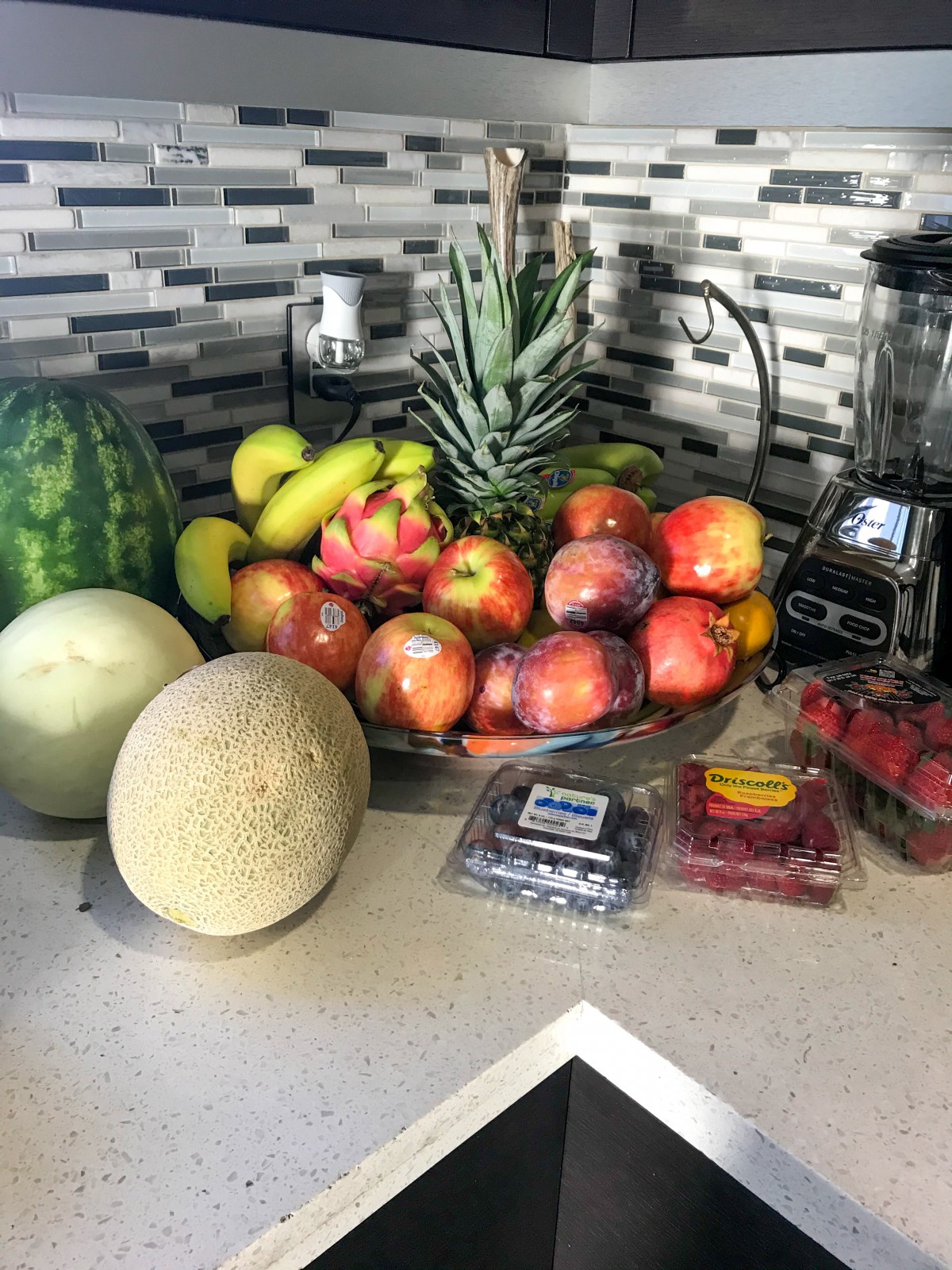 A variety of fresh fruits arranged on a kitchen counter.