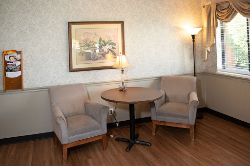 A cozy seating area featuring two armchairs, a small table, and a lamp, perfect for relaxation.