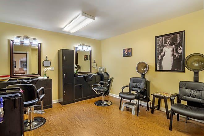 A tidy and well-organized hair salon with styling stations and chairs.