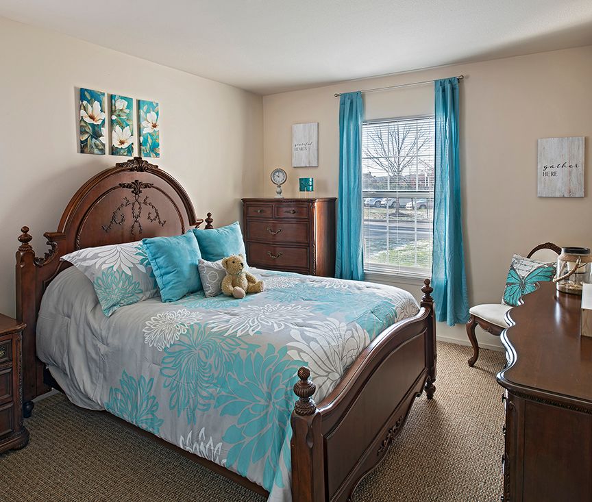 A cozy bedroom with a wooden bed frame and turquoise accents.