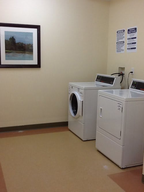 A clean and organized laundry room with a washing machine and dryer.