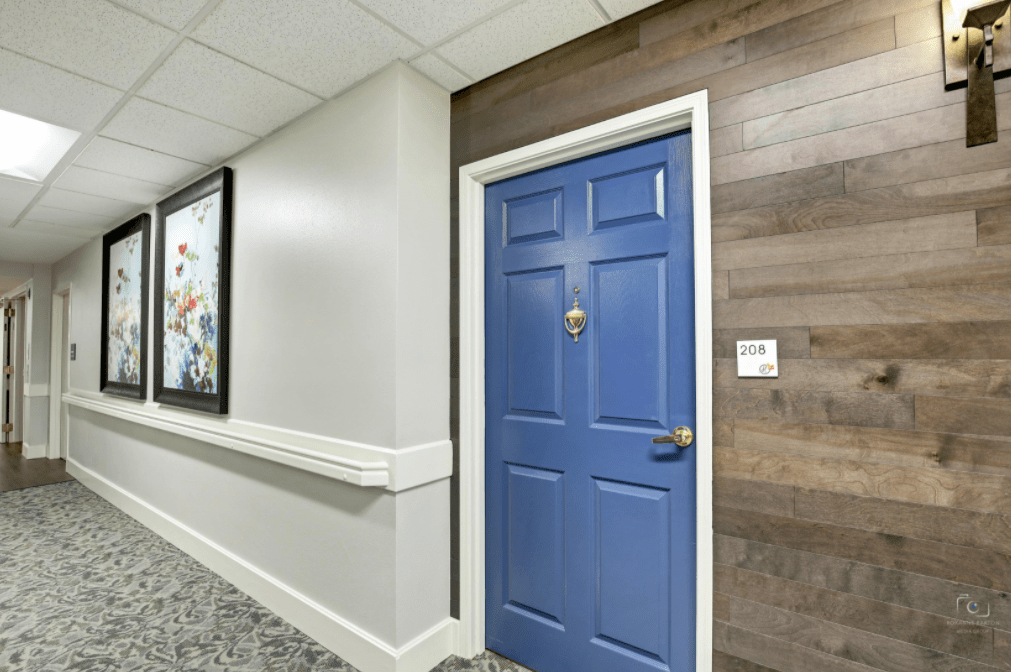 A hallway featuring a blue door and wall art.