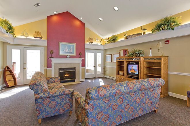 A cozy living room with a fireplace, sofas, and a TV.