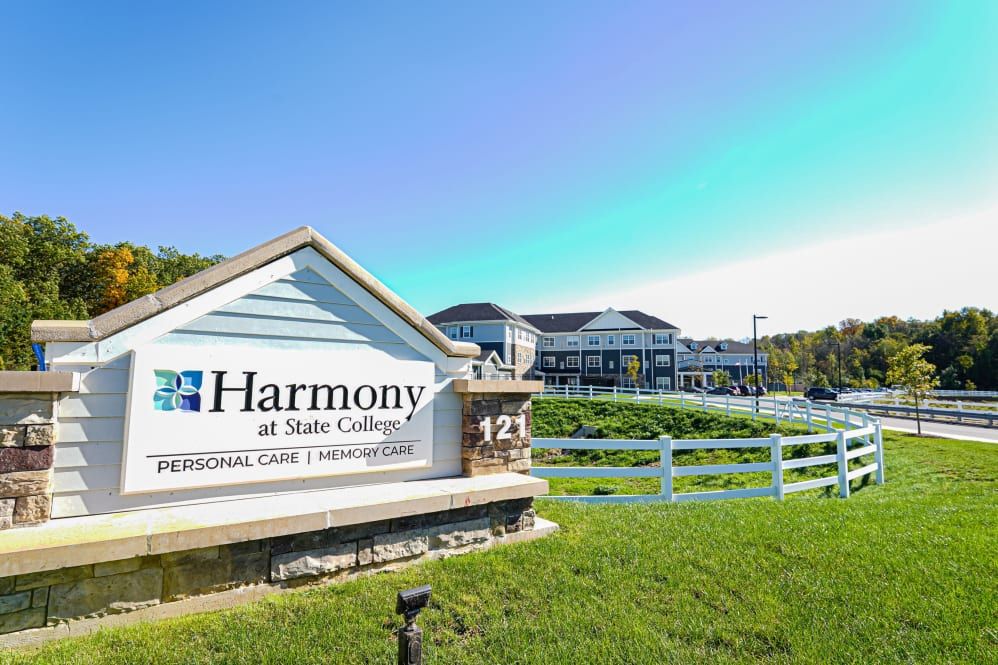 Harmony at State College senior living facility with a welcoming entrance and sign.