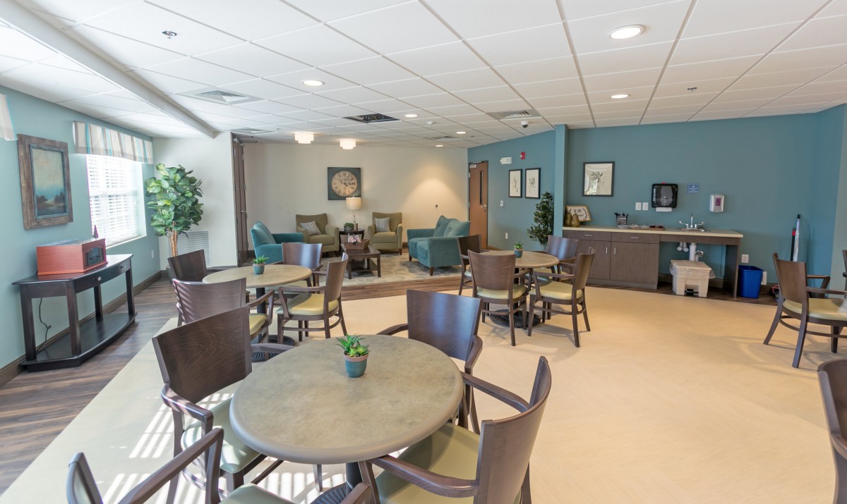 A modern lobby or waiting area with tables, chairs, and comfortable seating.