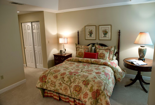 A cozy and elegantly decorated bedroom featuring floral bedding and decorative wall art.