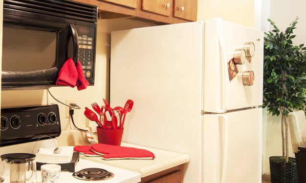 A kitchen with red-accented utensils and appliances.