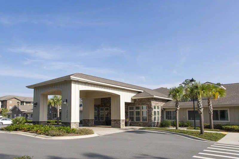 A commercial building with a covered entrance and surrounding landscaping.